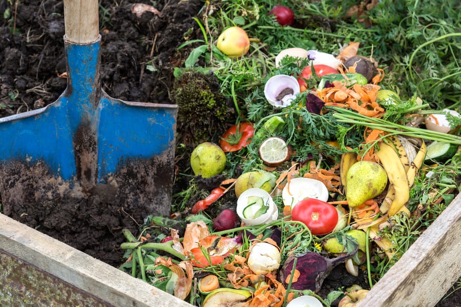 A Man Mixing Brown And Green In Compost Box