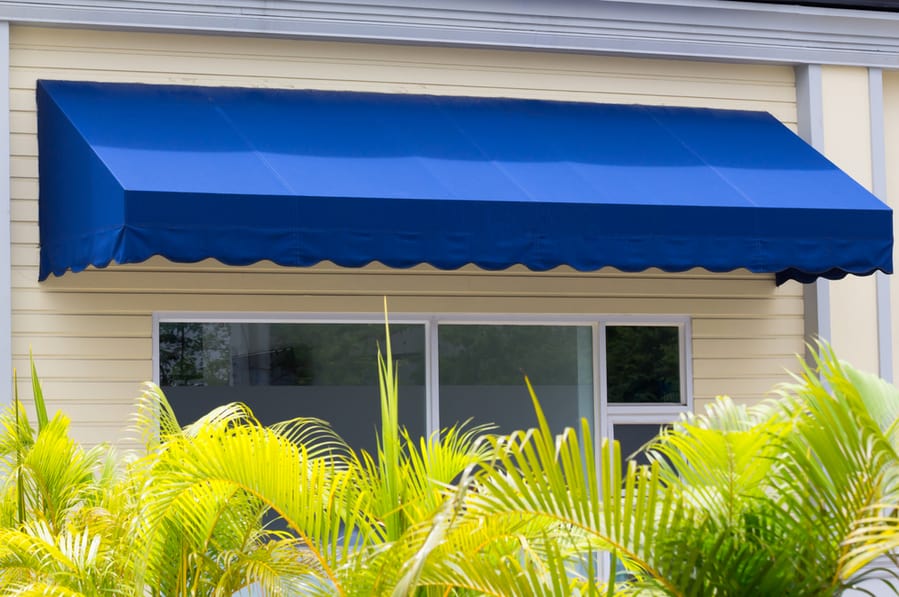 Blue Awning Over White Aluminium Frame Window Of Shop