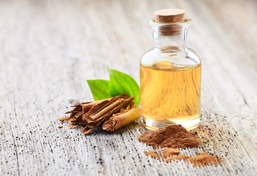 Cinnamon Bark With Essential Oil On Wooden Background