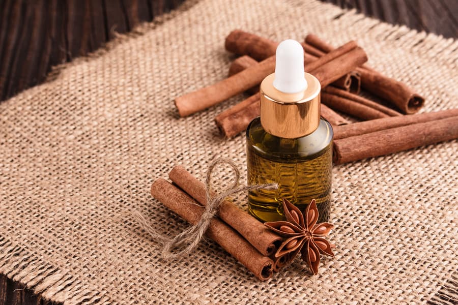 Cinnamon Essential Oil On A Wooden Background