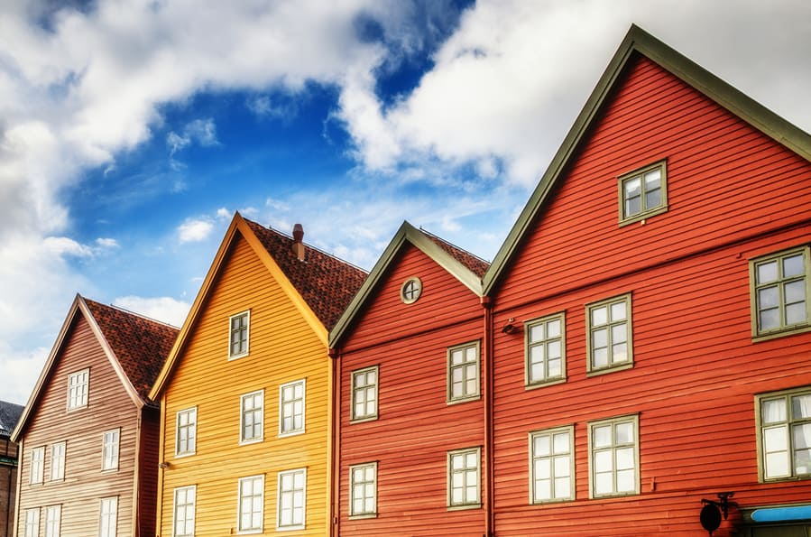 Color Houses Builings At Blue Sky With Clouds Background And Bright Windows Mirorred Sun Light In Sunset Time