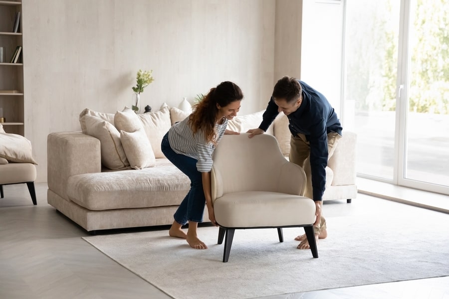 Couple Moving Furniture Into The Center Of The Room