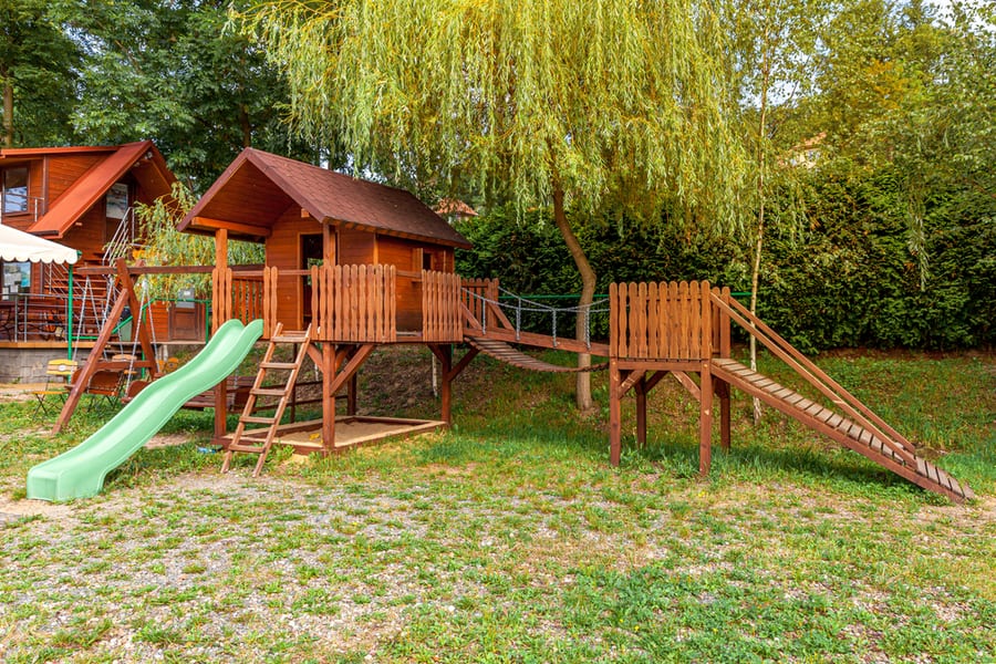 Empty Modern Wooden Children Playground Set On Green Yard In Public Park In Summer Day