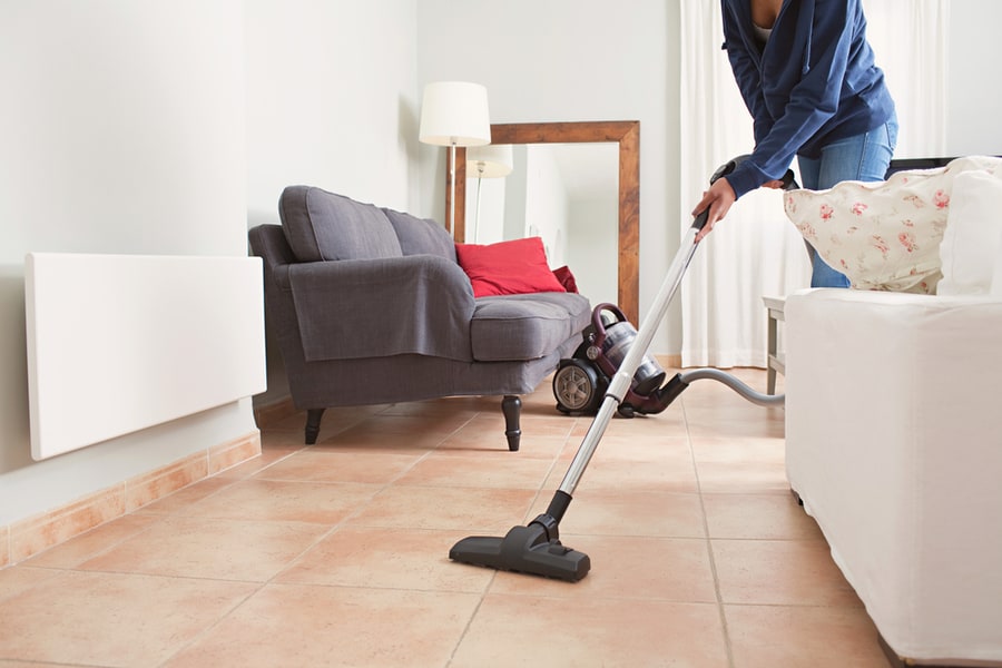 Faceless Middle Section Of Young Woman Using Vacuum Cleaner In Home Living Room Floor