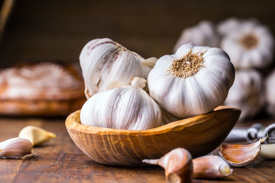 Garlic Cloves And Bulb In Vintage Wooden Bowl