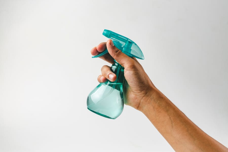 Hand Holding Plastic Spray Bottle