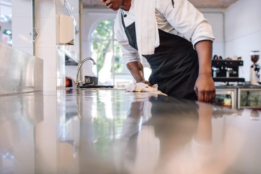 Man Cleaning And Maintaining Commercial Kitchen Hygiene