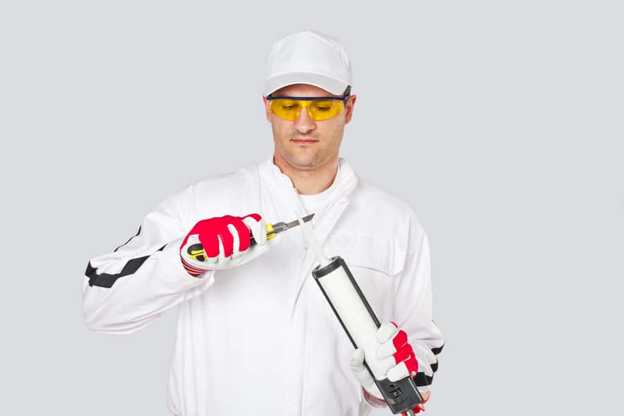 Man Holding A Silicone-Based Sealant