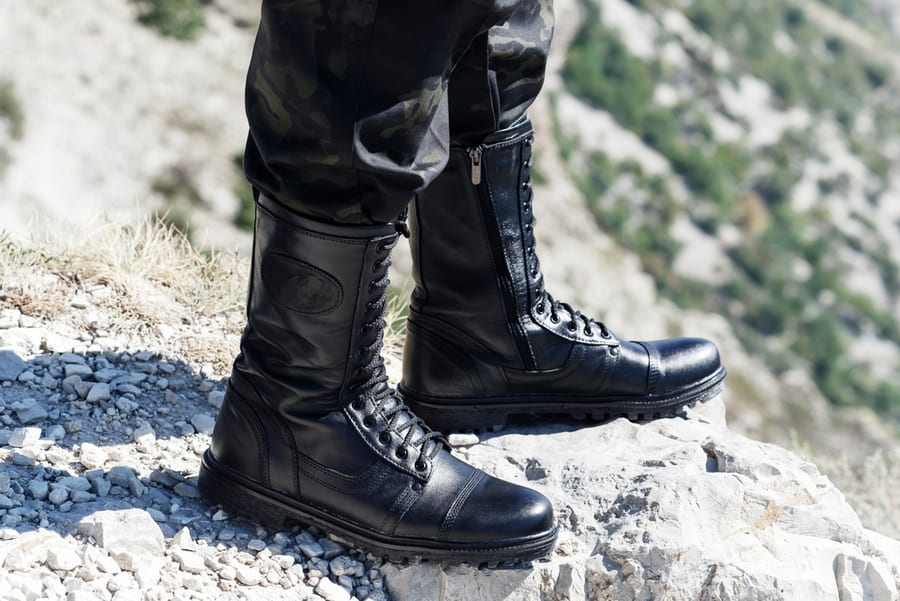 Man In Black Trousers And Boots On A Solid Background