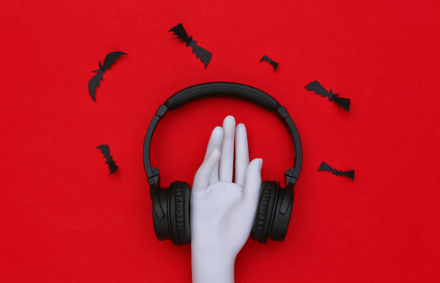 Mannequin Hand And Stereo Headphones With Bats On Red Background