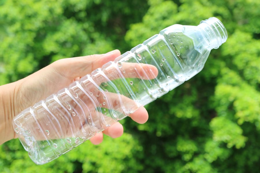 Man's Hand Holding An Empty Plastic Bottle