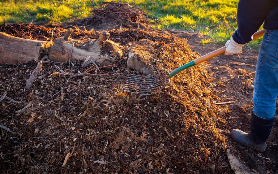 Person Building Permaculture Hill Mound Using Pitchfork In The Meadow