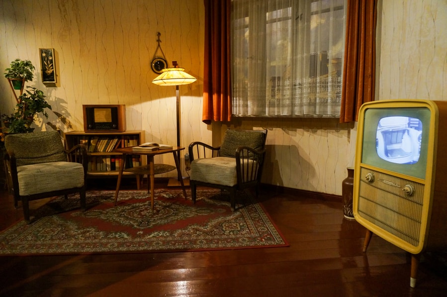 Soviet Interior With Vintage Tv, Lamp, Table, Carpet, Armchairs And A Wardrobe With Old Books