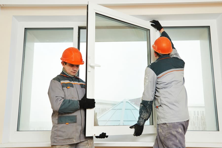 Two Male Industrial Builders Workers At Window Installation