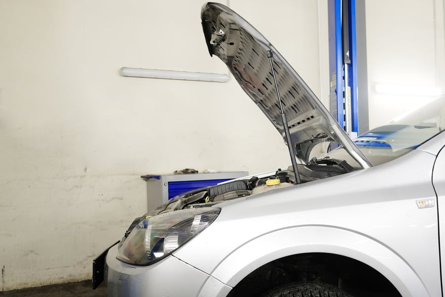 White Car With Open Hood In The Garage