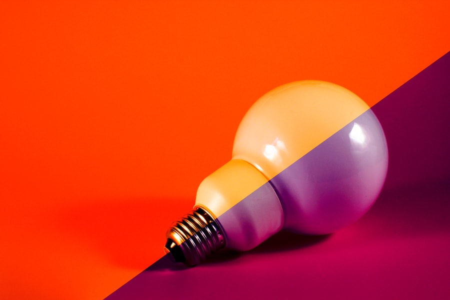 White Lightbulb On Purple / Orange Background And Space For Copy