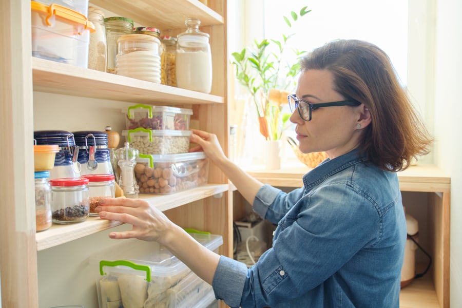 Woman Storing Food Properly On Shelves