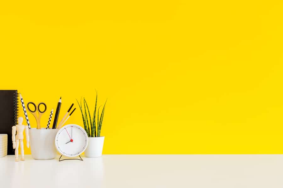 A Desk Table Against A Yellow Wall