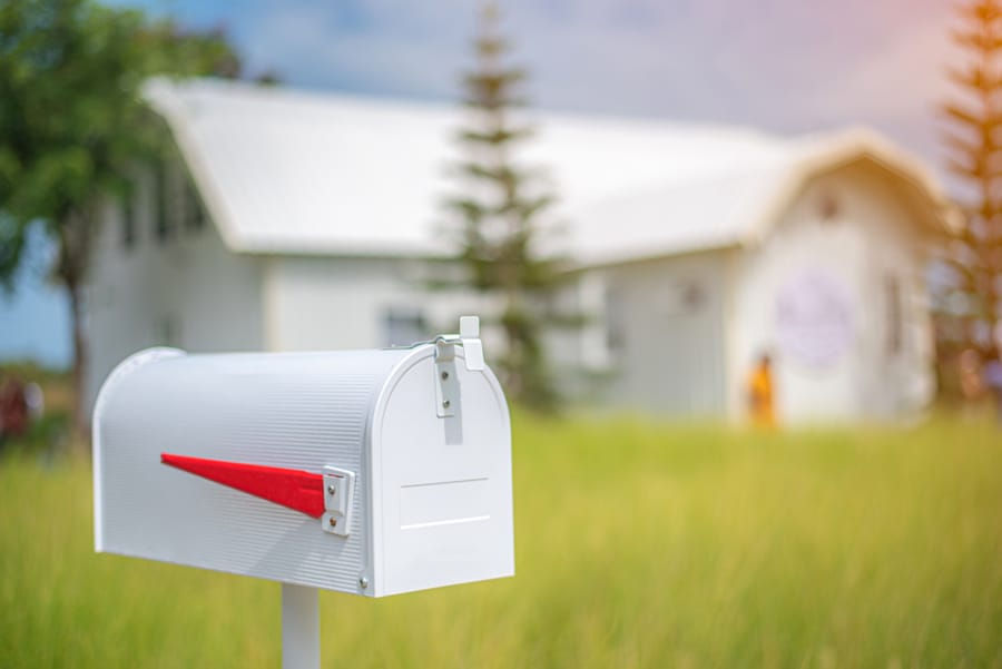 White Mailbox In Front Of House Background During Early Morning Light