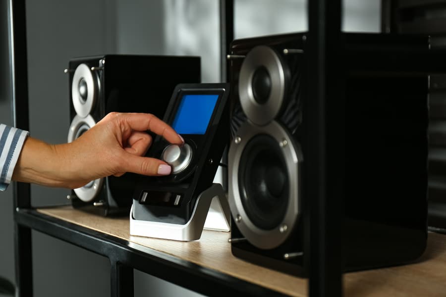 Woman Adjusting The Volume Of Speakers