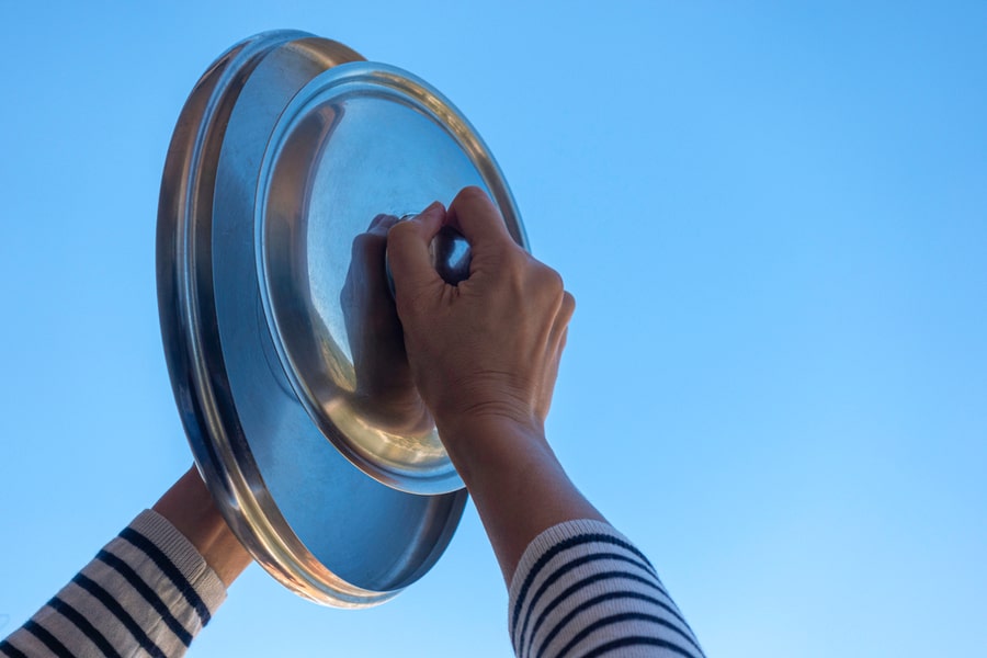Woman Hands Banging Pot Lids Against Blue Sky. Banging Pots And Pans From The Windows And Balcony