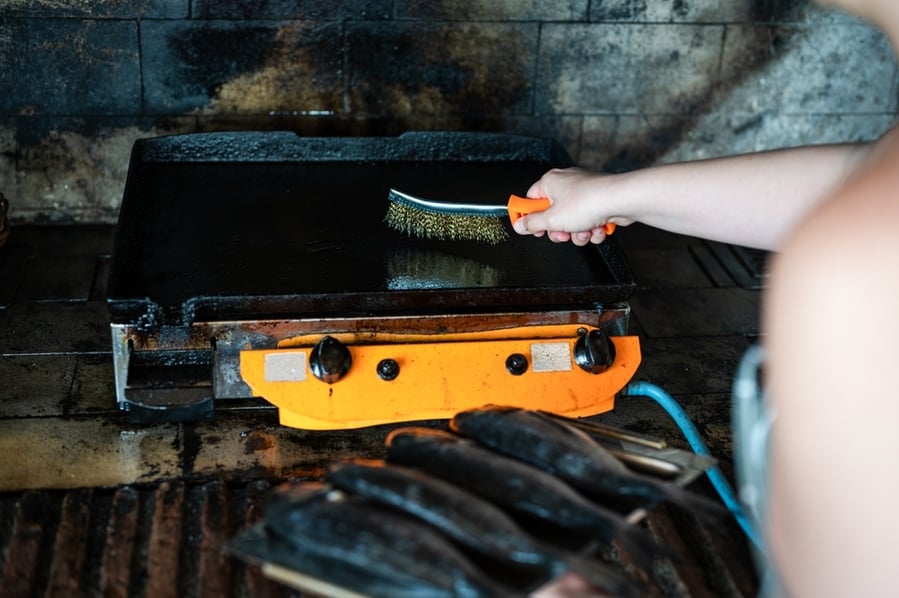 Woman Scrubbing Griddle Plate Steel