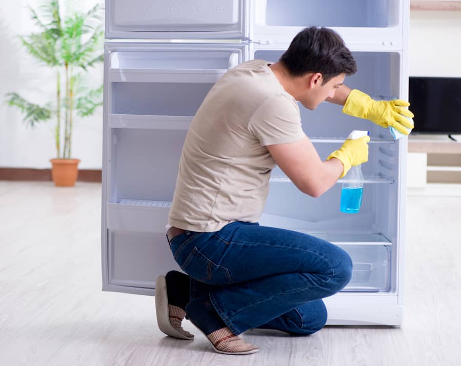 A Man Thoroughly Cleaning His Fridge