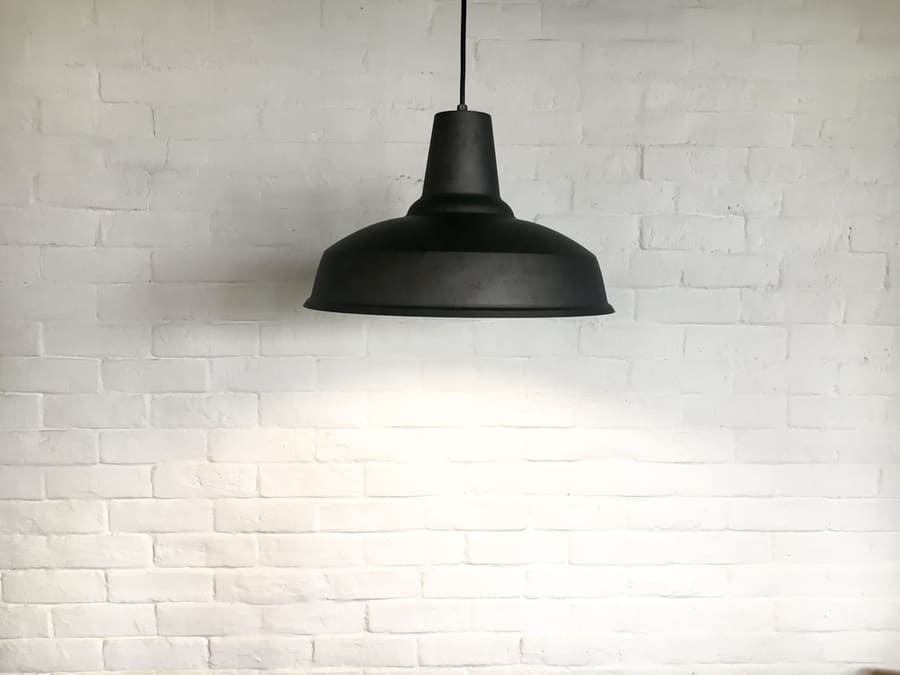 Black Fixture Of Lamp Have White Bricks Wall As Background.