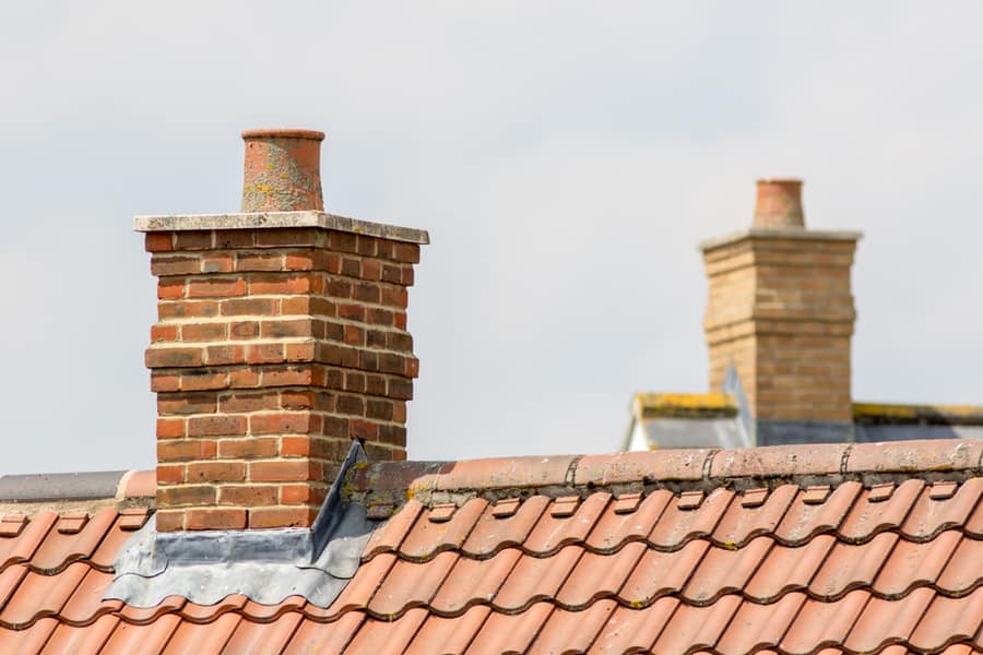 Brick Chimney Stack On House Roof Top.