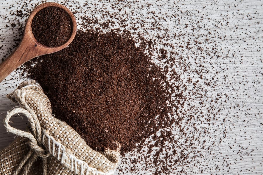 Ground Coffee With Burlap Bag On The Wooden Table In The Kitchen.