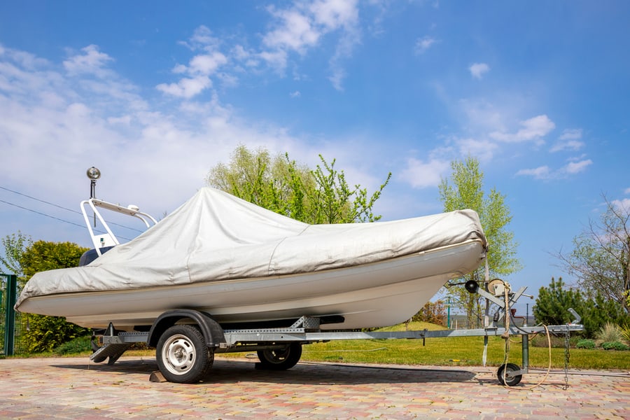 Motorboat Ship Covered With Grey Or White Protection Tarp