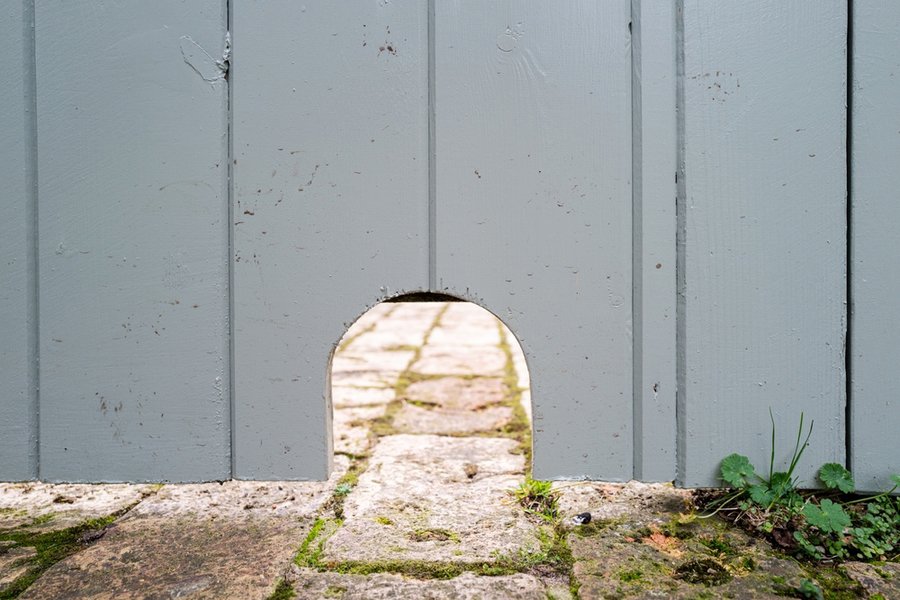 Newly Cut Small Hedgehog Entrance Hole At The Bottom Of A Garden Gate