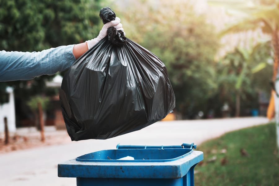 Hand Holding Garbage Black Bag Putting In To Trash