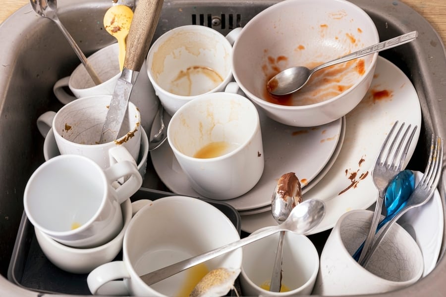 Pile Of Unwashed, Dirty Dishes In The Sink